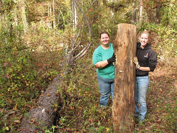 Sylvia Pitts and Samantha Marcella removing logs from trail