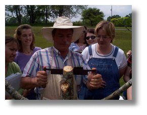 Amling uses a draw knife to expose the bark tissue